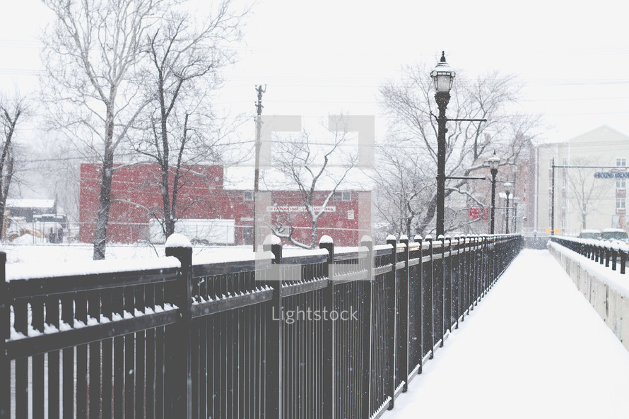 snow on a bridge and railings 