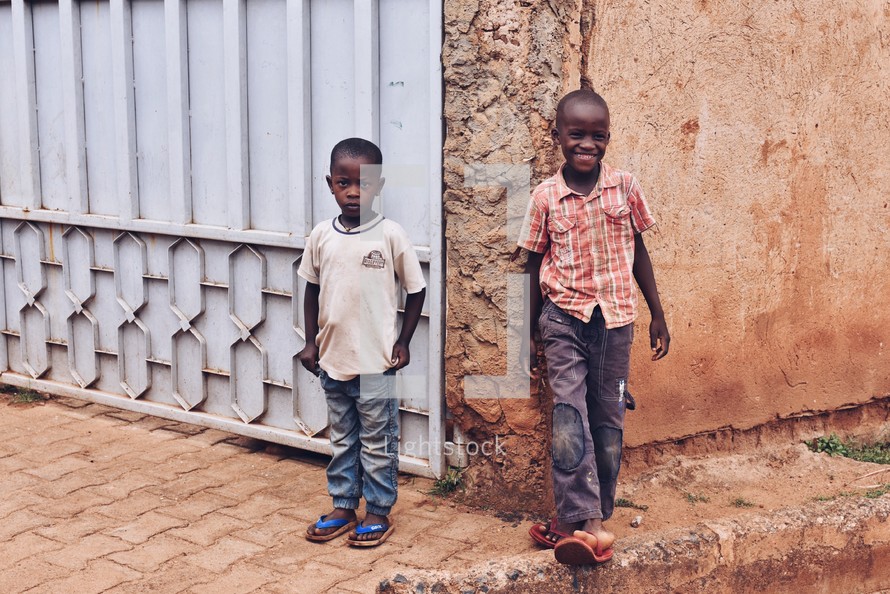children leaning against the corner of a building exterior 
