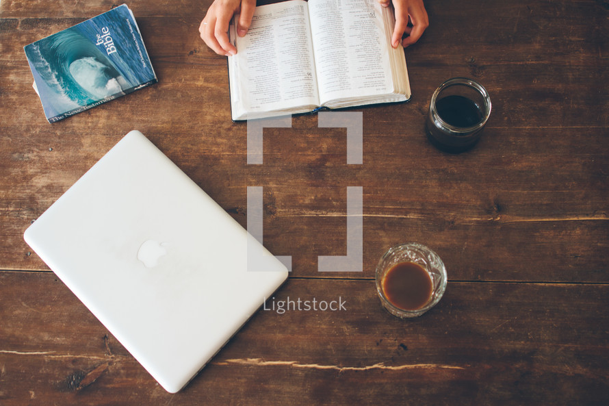 woman reading a Bible and a closed laptop 
