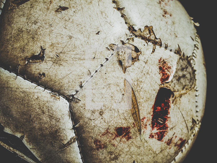 White soccer ball with blood, mud, and scratches