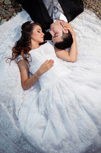portrait of a bride and groom lying on the ground 