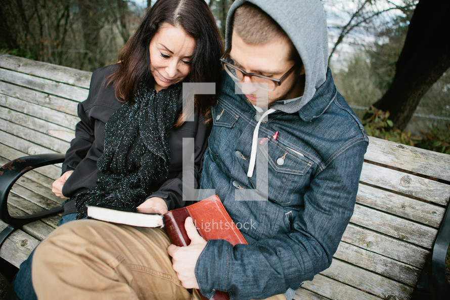 mother and son reading a Bible together and praying together 