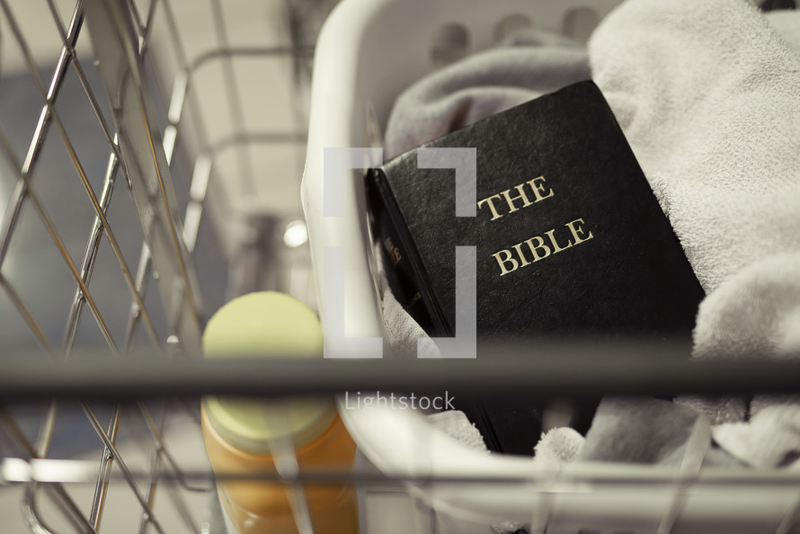 a Bible on top of folded laundry 