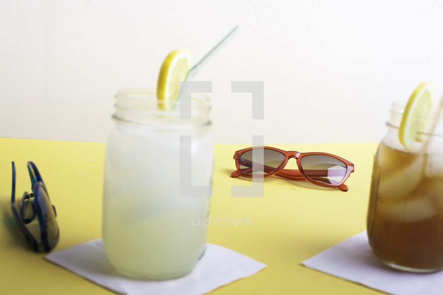 lemonade and iced tea on a table with sunglasses 