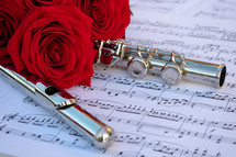 red rose and flute on sheet music 