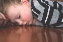 napping child on a wood floor 