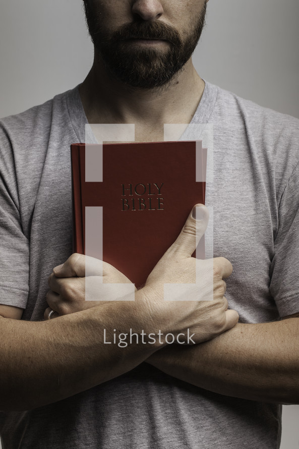man holding a Bible against his chest 