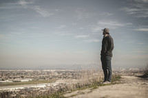 a man standing at the top of a sandy hill 