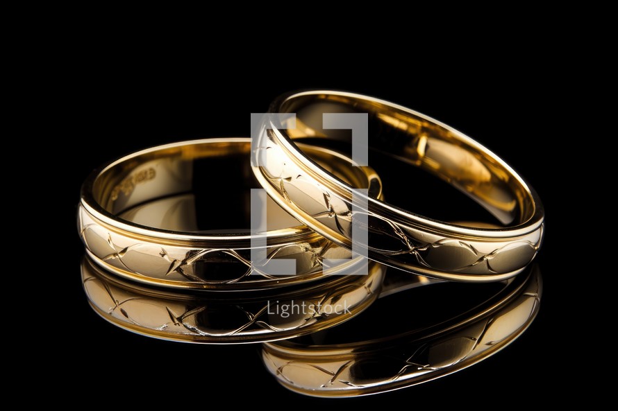 Sacrament: Matrimony. Wedding rings isolated on black background. Golden wedding rings.