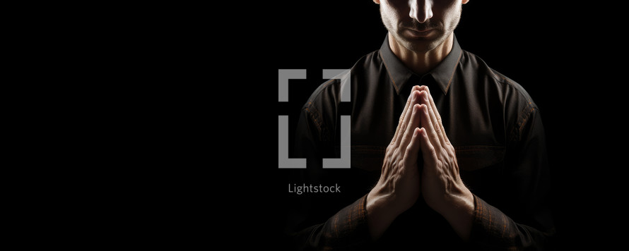 Praying man isolated on black background with copy space
