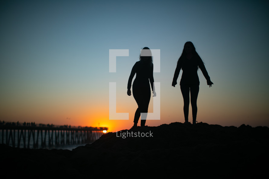 two women standing on a beach 