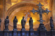 Decorative cross with statures of disciples and saints in a cathedral dome.