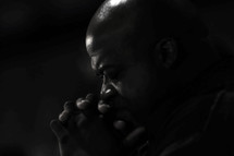 Man praying in darkness.