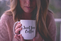 a woman holding a quiet time coffee mug 