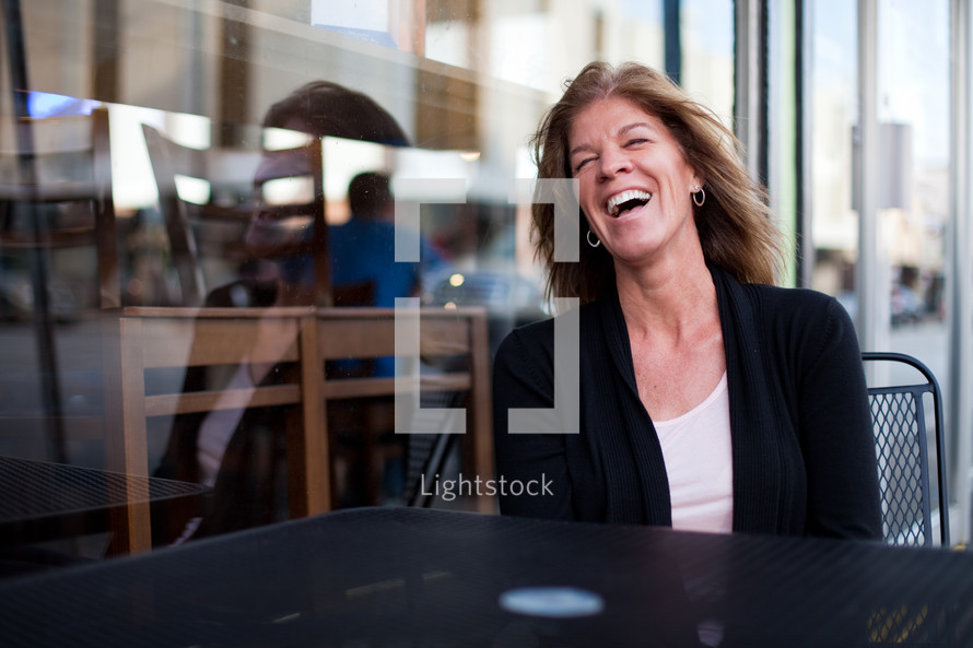 Joyful woman at an outdoor cafe.