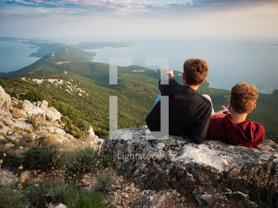 two guys relaxing in front of an island peninsula view