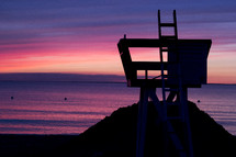 lifeguard stand on a beach at sunset 