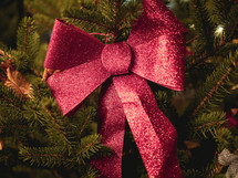 red glittery bow on a Christmas tree
