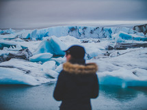 a woman looking out at icebergs 