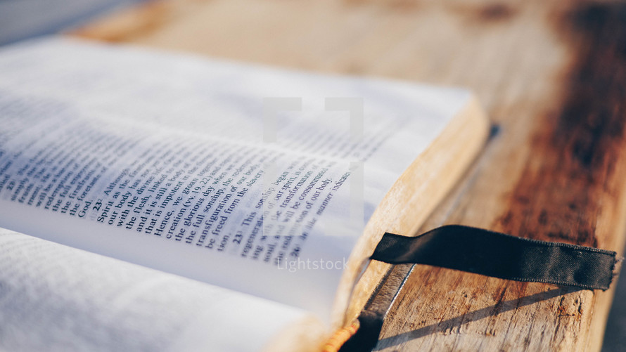 open Bible on a wood railing 