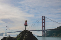 person standing on a hill and Golden Gate Bridge in the background 