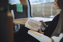 Girl reading her bible on en empty train. 