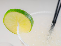 Colorful bright cocktail decorated with ice, sugar and lime. Cooling drink.
