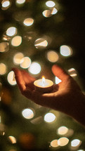 votive candle in a cupped hand 