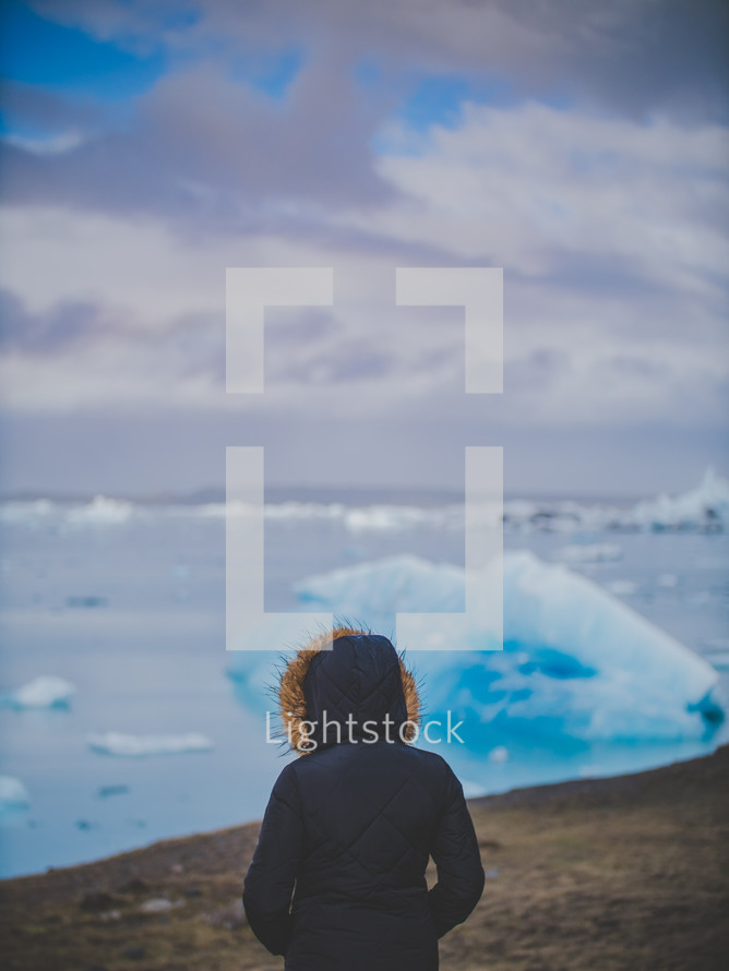 a woman looking out at icebergs 