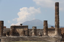 Roman columns in a ruins with Mt Vesuvius in the background 