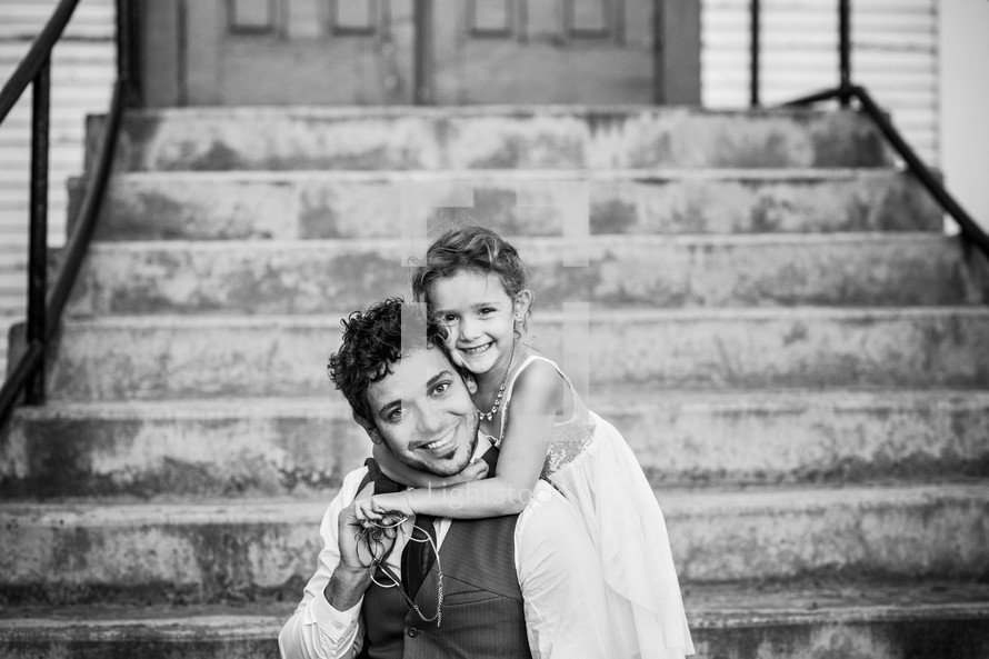 father and daughter hugging on church steps 