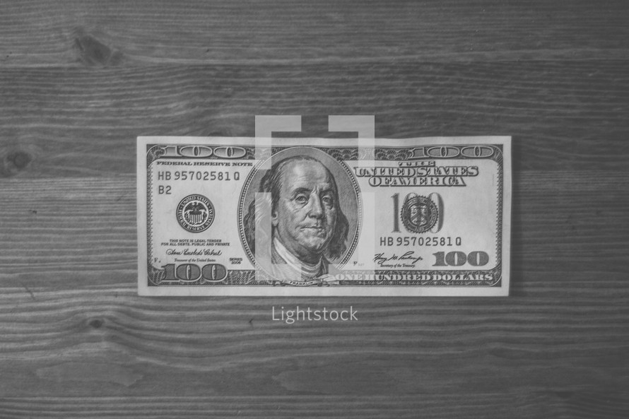 Hundred dollar bill on wood.