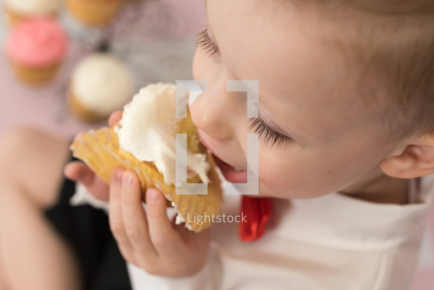 a toddler eating a cupcake 