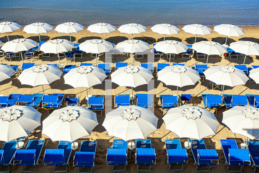 Follonica bathhouse seen from above, white umbrellas and blue beds