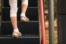 a child climbing up steps on a playground 