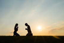 a couple kneeling in prayer 