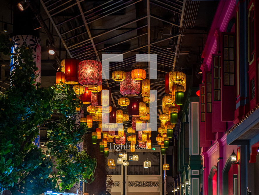 paper lanterns above a sidewalk at night 