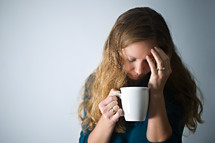 stressed woman holding a mug of coffee