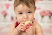 an infant eating a cookie 