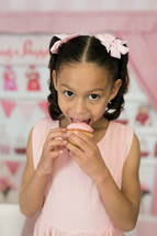 a girl eating a cupcake 