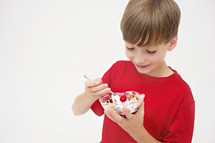 boy child eating a bowl of ice cream 