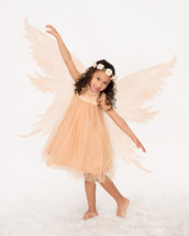 A little girl posing in a fairy costume.