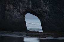 arch in rock along a shore 