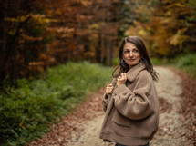 Woman posing on path through fall trees