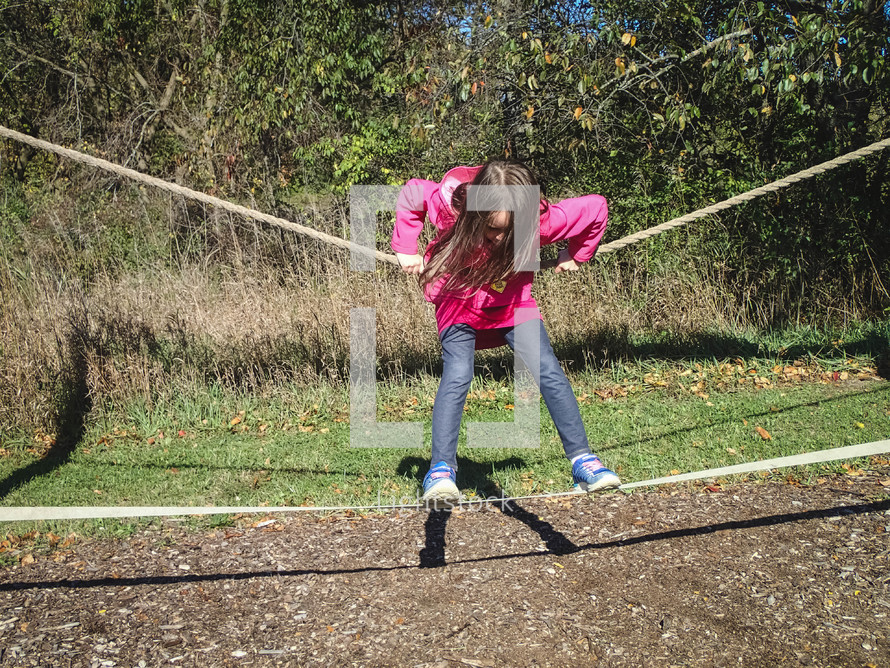 a child balancing on a tight rope 