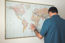 a man with his hands on a world map 