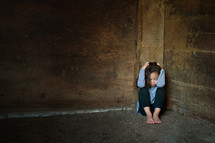 young girl hiding in a corner 