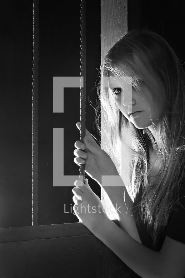 teen girl holding onto bars 