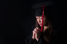 face of a female graduate in prayer 
