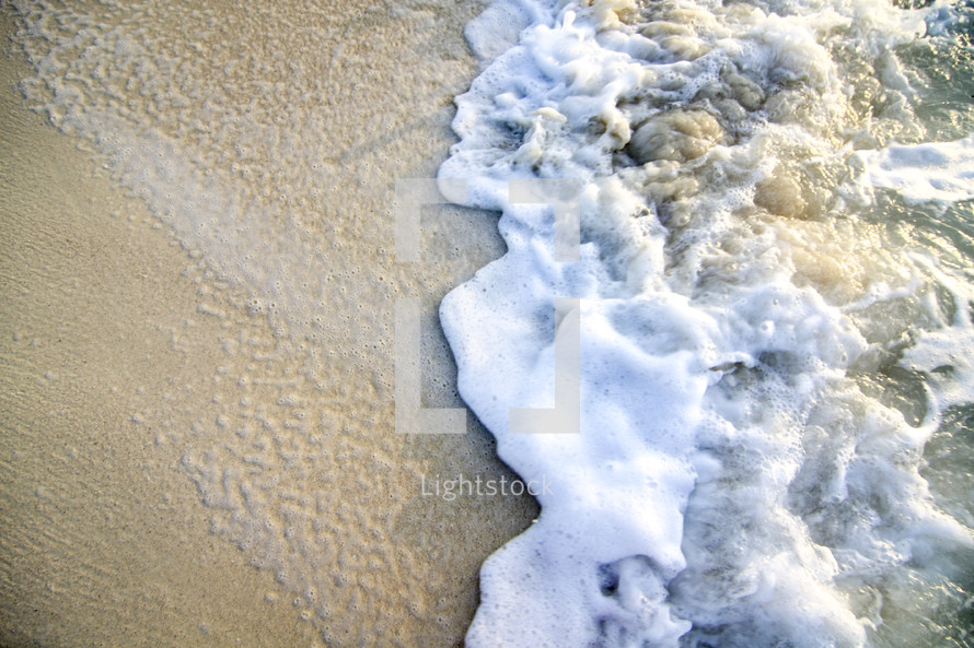sea foam on sand on a beach 